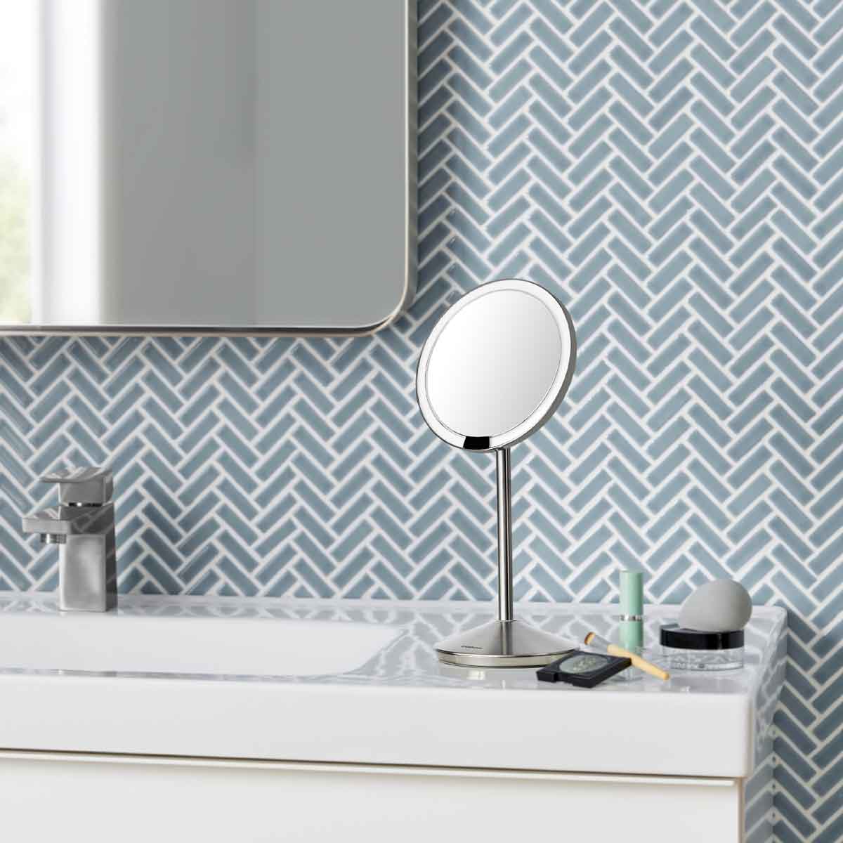 sensor mirror fold - brushed finish - lifestyle on bathroom sink with cosmetics image