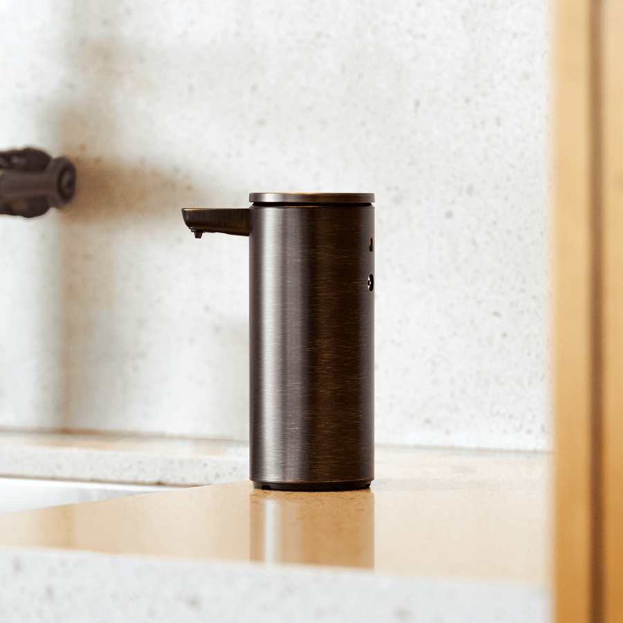 Profile view of Simplehuman 9 oz. Rechargeable Sensor Pump, Bronze finish, touch-free dispensing on modern counter.
