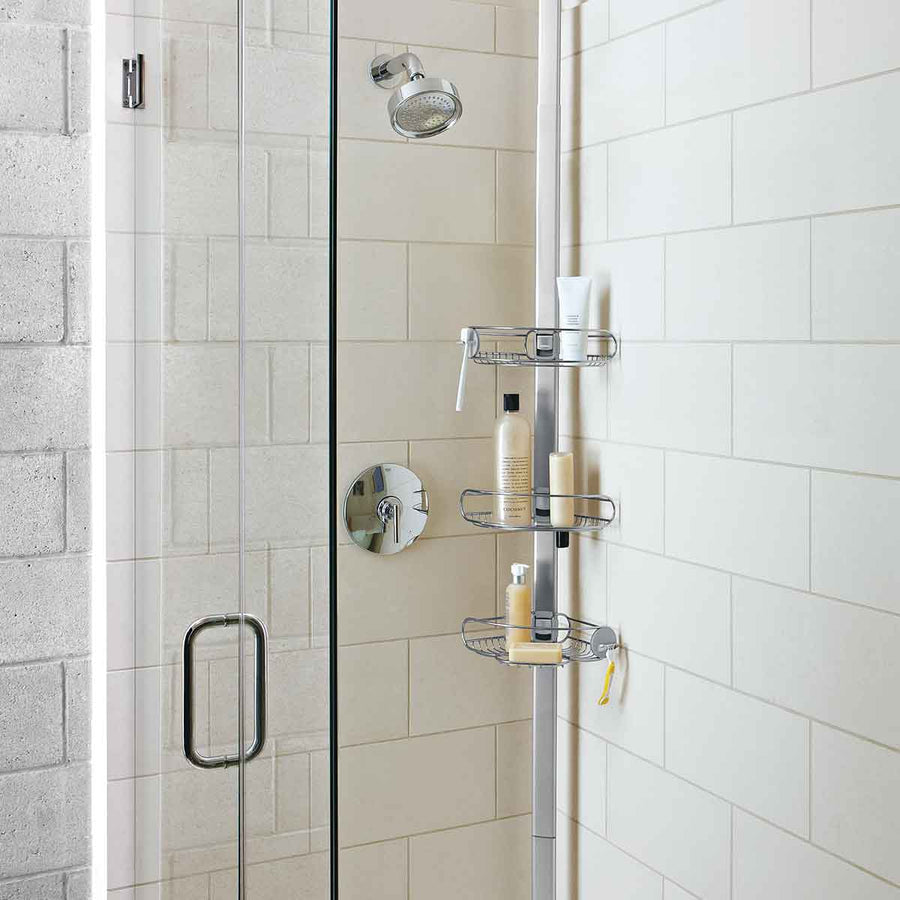Angled view of Simplehuman Polished Stainless Steel Tension Shower Caddy, 3 adjustable shelves for shower organization.