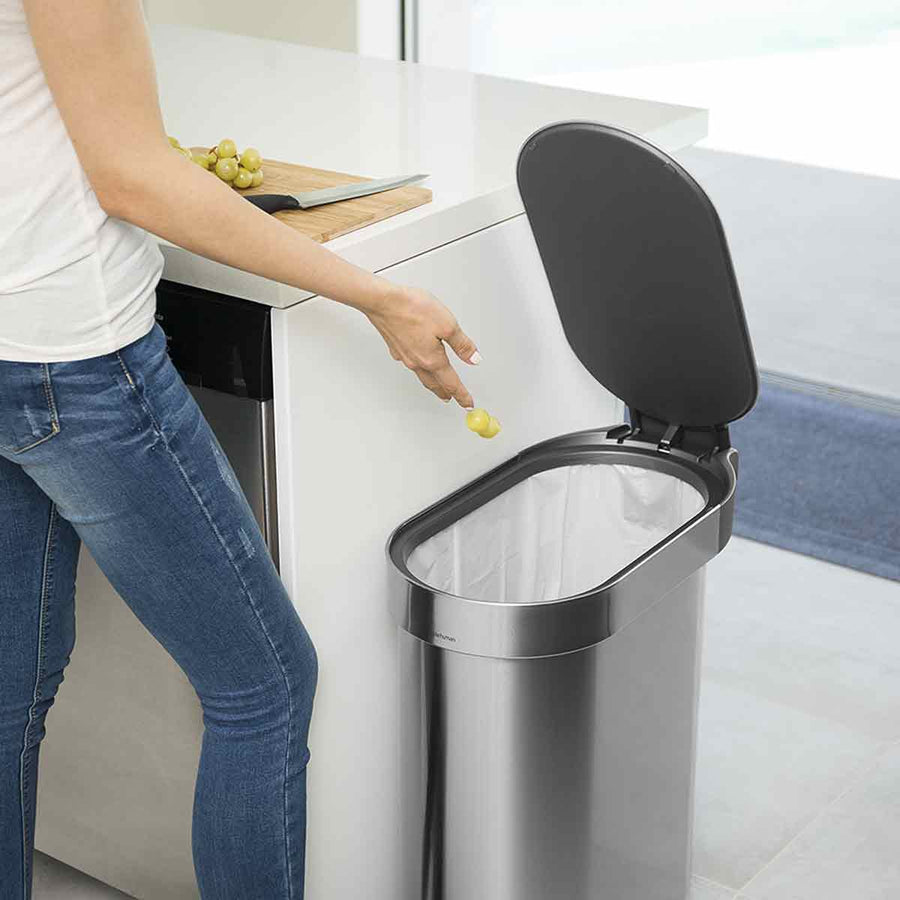 Simplehuman 45L Slim Step Can in Brushed Stainless Steel used in kitchen, open lid reveals secure liner rim.