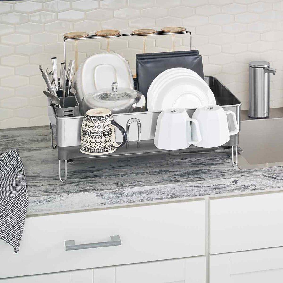Angled view of Simplehuman Brushed Stainless Steel Steel Frame Dishrack in use with removable caddy and integrated cup drying.