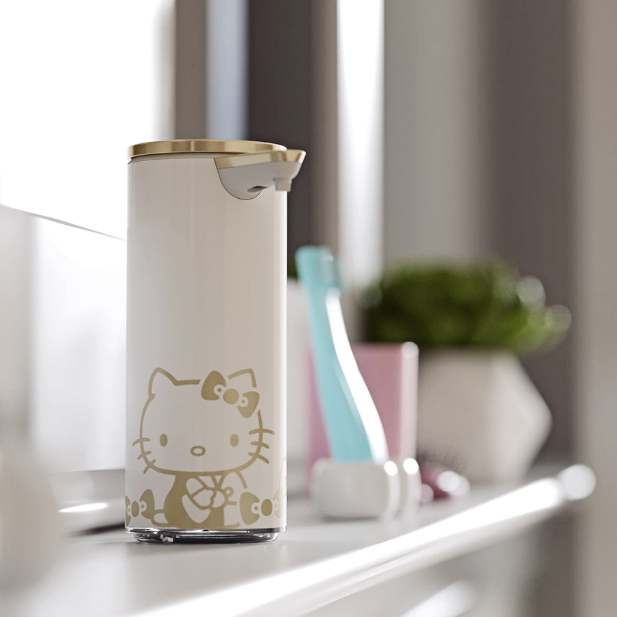 Angled view: Simplehuman 9 oz. Rechargeable Sensor Pump (White/Brass) Hello Kitty edition on a bathroom shelf.