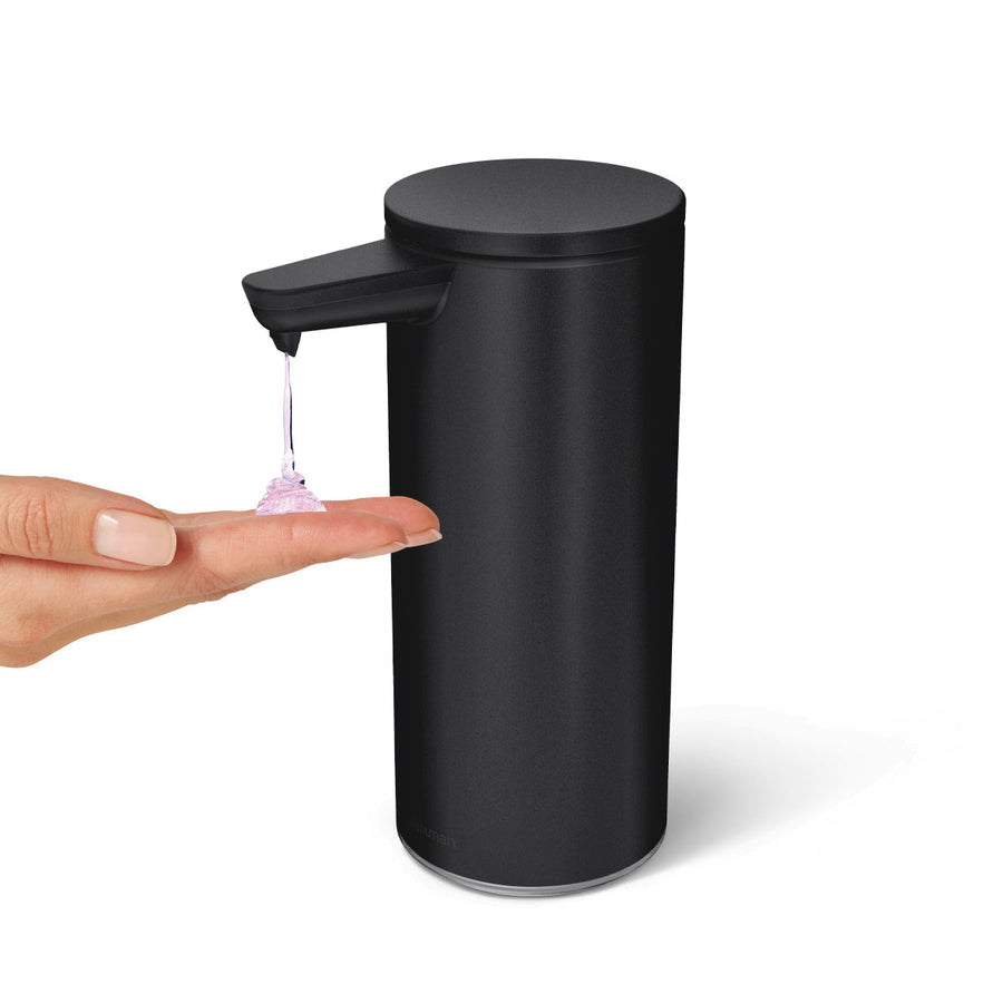 Angled view of Simplehuman 9 oz. Sensor Pump in Matte Black dispensing liquid soap onto a hand, hands-free usage.