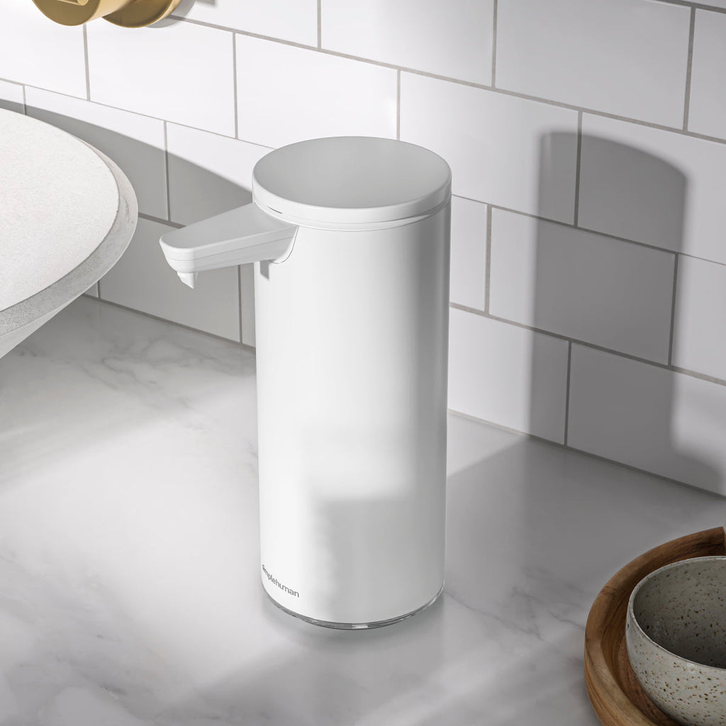 Simplehuman 9 oz. Sensor Pump, White, angled view on marble counter in modern bath or kitchen, touch-free.