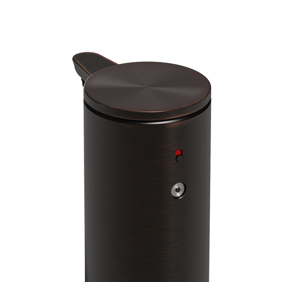 Detail view of Simplehuman 9 oz. Sensor Pump, Bronze, showing magnetic charge port and red power indicator.