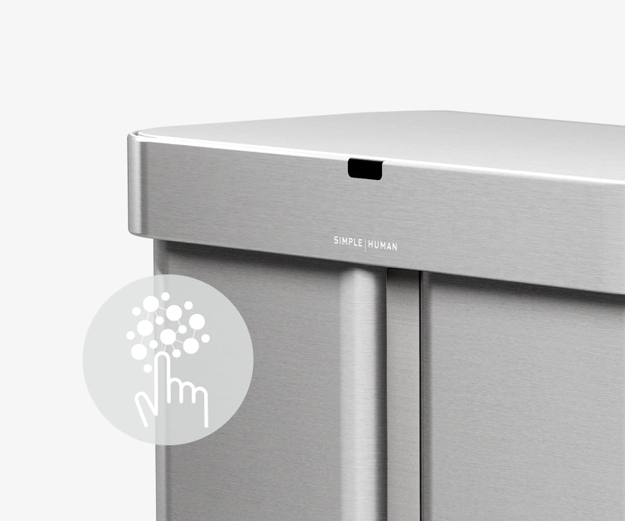 This image of Simplehuman's 58L Sensor Can in Brushed showcases an icon describing how the can has a silver ion-coating that resists both fingerprints and the spread of germs.