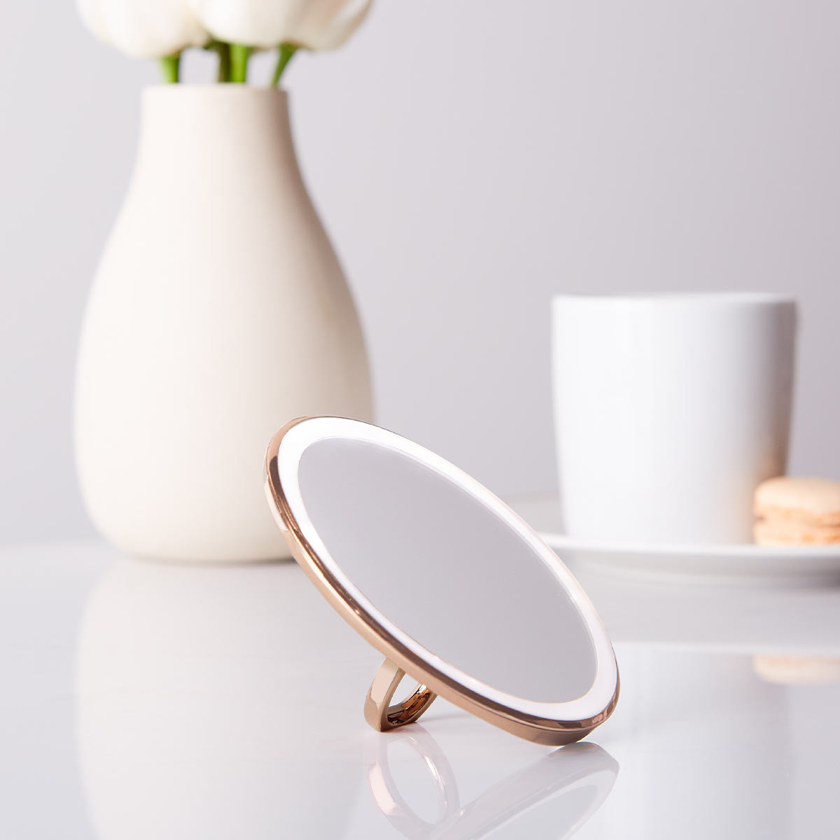 sensor mirror compact 10x - rose gold finish - lifestyle using ring holder stand