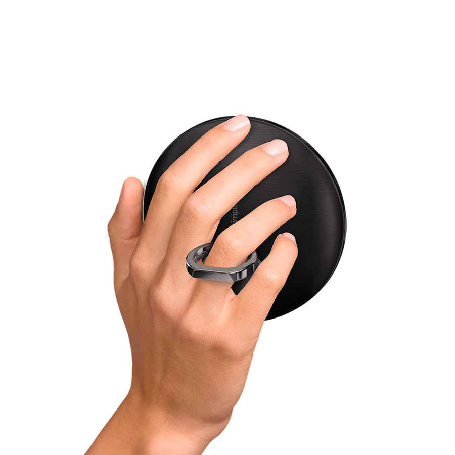 Simplehuman Sensor Mirror Compact 3x, Matte Black, held closed using the integrated finger ring for secure carrying.