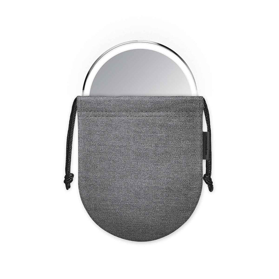 View of Simplehuman Sensor Mirror Compact 3x, Brushed Stainless Steel, tucked into the gray protective drawstring pouch for travel.