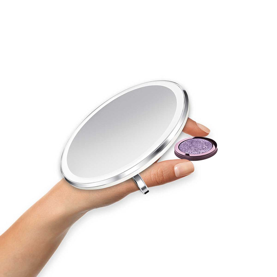 Simplehuman Sensor Mirror Compact 3x, Brushed Stainless Steel, held securely with the ring while applying makeup.