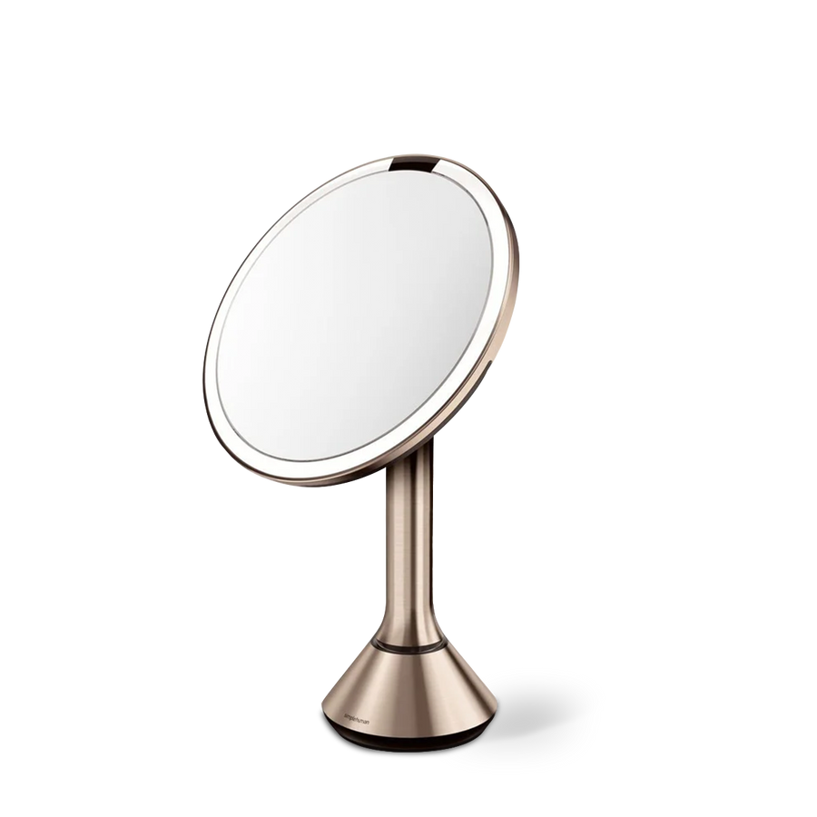 Angled view of Simplehuman Rose Gold Sensor Mirror Round with touch-control brightness and dual light setting.
