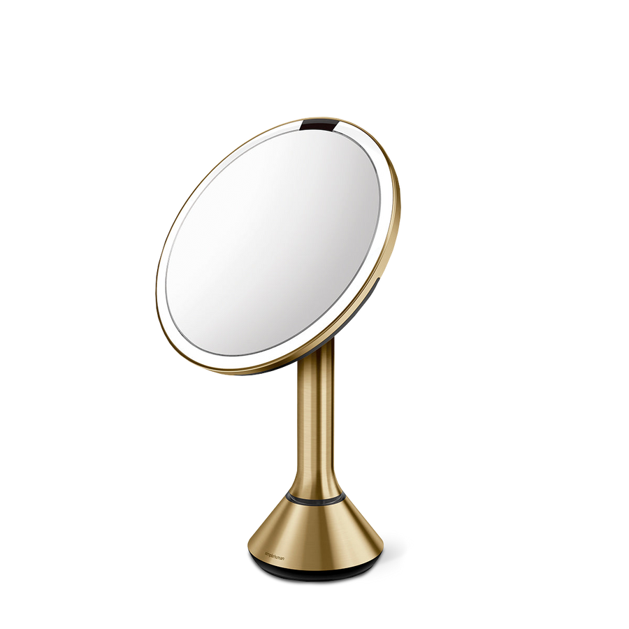 Angled view, Simplehuman Brushed Brass Sensor Mirror Round with dual light settings and adjustable pivot.