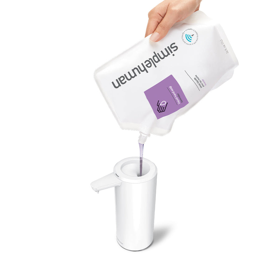Refilling view of Simplehuman 9 oz. Rechargeable Sensor Pump in White using soap pouch, wide opening for easy refill.