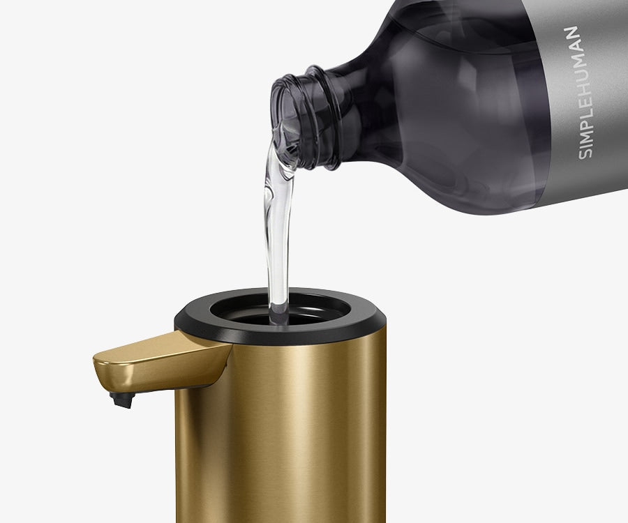 Simplehuman's Sensor Pump with a Simplehuman Refill Bottle pouring soap into the pump. 