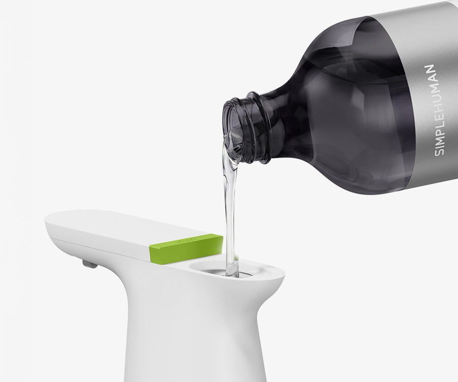 Simplehuman's Sensor Spray with a Simplehuman Refill Bottle pouring soap into the spray. 
