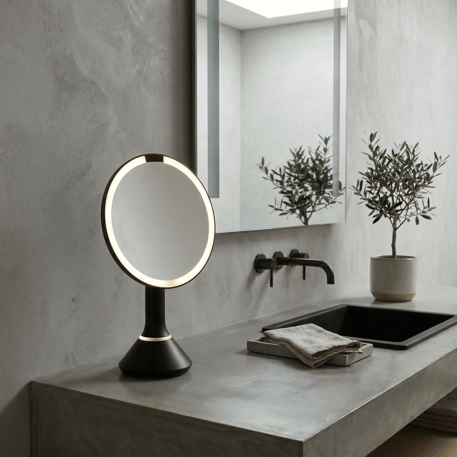 Simplehuman's Sensor Mirror Round in Matte Black in a modern bathroom setting.